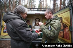 Протоиерей Николай (Гвоздев) и военнослужащий во время рождественского молебна для военнослужащих группировки войск "Центр"